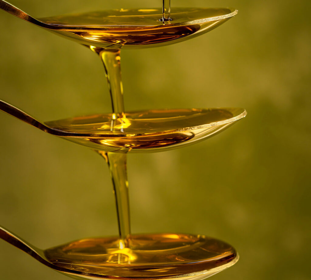 Golden-green extra virgin olive oil being poured
